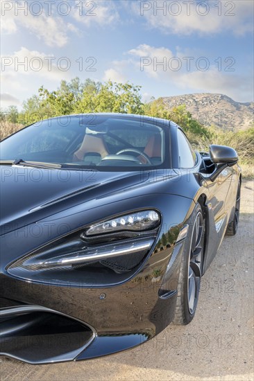 A partial front view of a black McLaren 720S