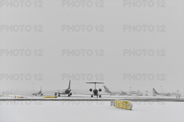 Aircraft in wait in winter snow flurry for de-icing and take-off clearance