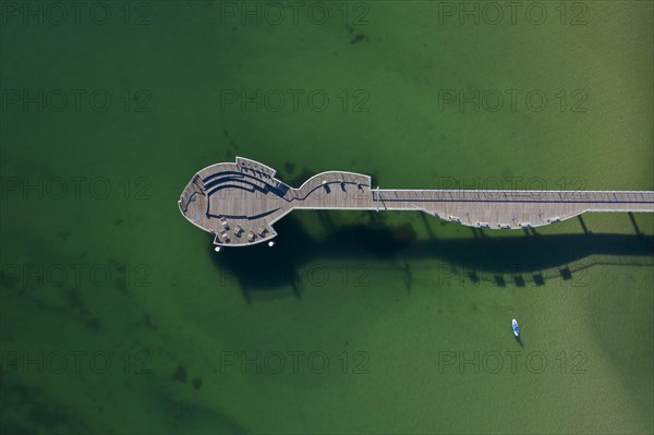 Aerial view over wooden fish-shaped pleasure pier at seaside resort Niendorf along the Baltic Sea