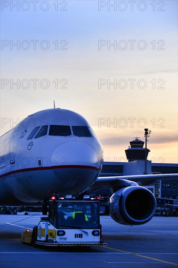 Agean Airlines aircraft towing in front of Terminal 2 in the sunset