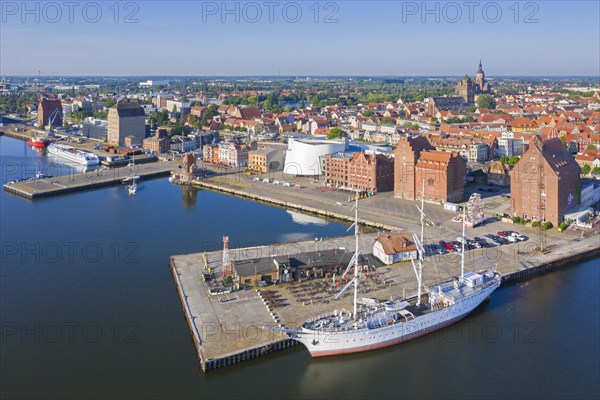 Aerial view over public aquarium Ozeaneum and three-mast barque Gorch Fock docked in harbour of the city Stralsund