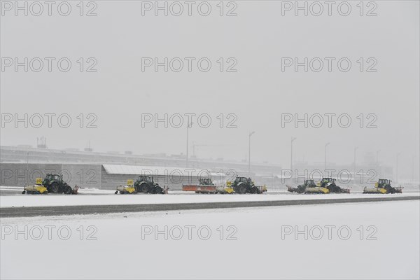 Snow clearing machines and snow removal tractors clearing snow on the apron Cargo