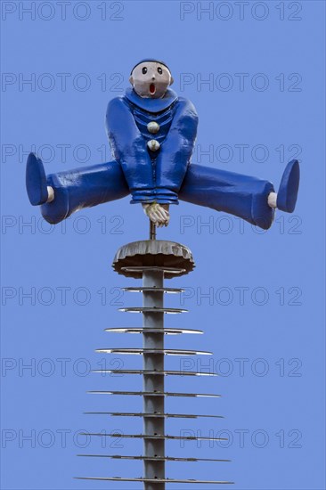 Sculpture showing Pierrot leapfrogging over crown-cap