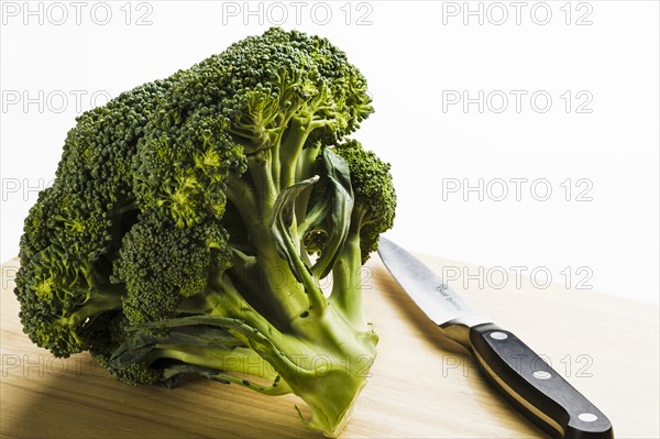 Broccoli head on wooden chopping board