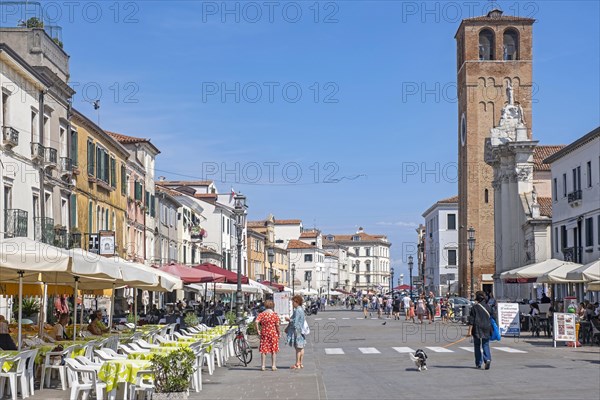 Bell tower and restaurants in the town Chioggia on small island at southern entrance to Venetian Lagoon near Venice
