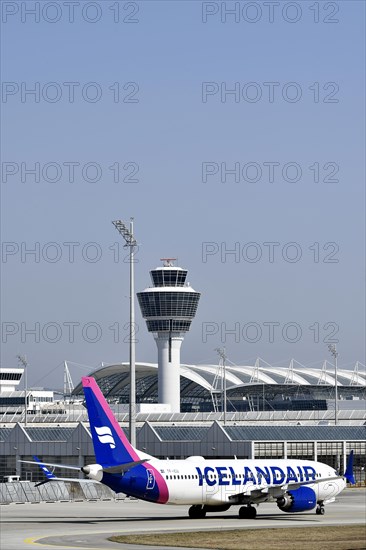 Iceland Air aircraft Boeing B737 MAX taxiing with Terminal 1 and Tower