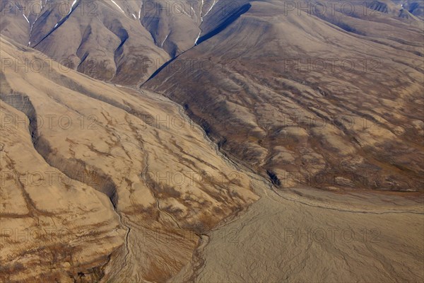 Aerial view of deep gullies carved by water erosion and U-shaped valley created by retreating glacier at Spitsbergen