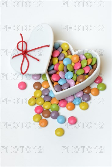 Chocolate lentils in heart-shaped container, Smartie