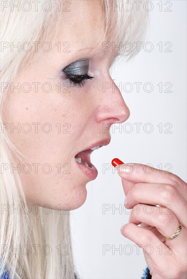 Woman holding a painkiller between finger