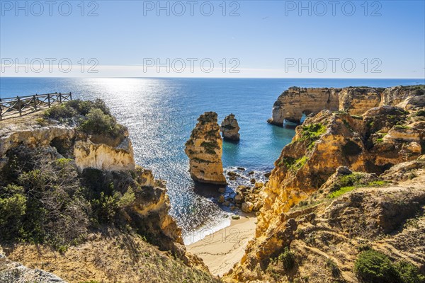 Beautiful cliffs and rock formations by the Atlantic Ocean at Marinha Beach in Algarve, Portugal, Europe