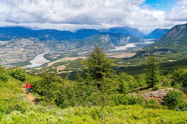 Hikers climbing to the lagoon on Cerro Castillo mountain, with the river valley of the Rio Ibanez in the background, Cerro Castillo National Park, Aysen, Patagonia, Chile, South America