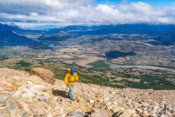 Hikers climbing to the lagoon on Cerro Castillo mountain, with the river valley of the Rio Ibanez in the background, Cerro Castillo National Park, Aysen, Patagonia, Chile, South America