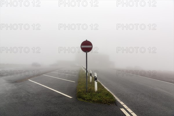 Empty car park at Koeterberghaus with one-way street sign, dreary autumn weather with fog, mountain peak, Koeterberg, Luegde, Weserbergland, North Rhine-Westphalia, Germany, Europe