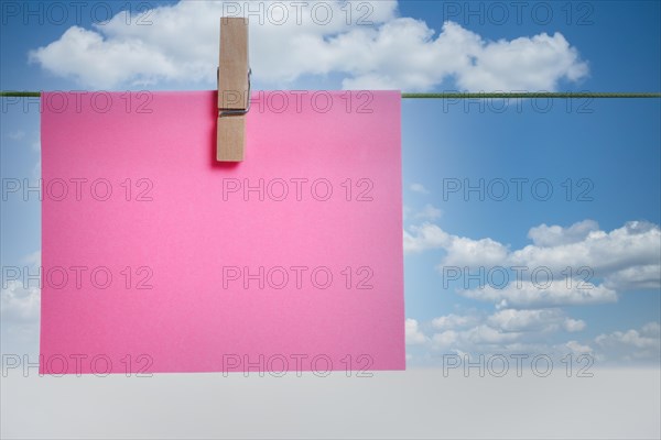 Colorful post it on a clothesline with cloudy sky in the background