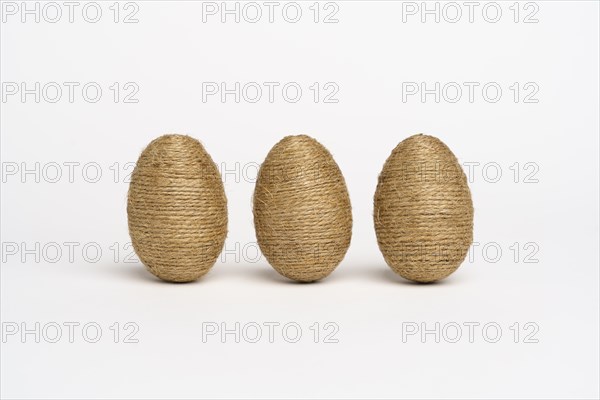 Hand wrapped easter eggs with jute twine, isolated white background. Studio