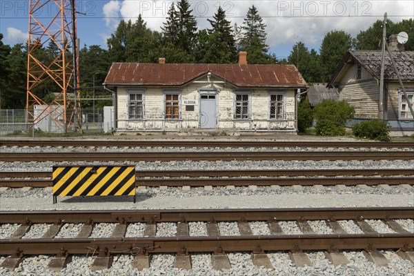 Railway tracks and weathered wooden house at the historic railway station in the village of Klooga, Harju County, Estonia, Europe