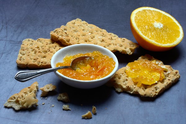 Orange marmalade in small bowls and on crispbread