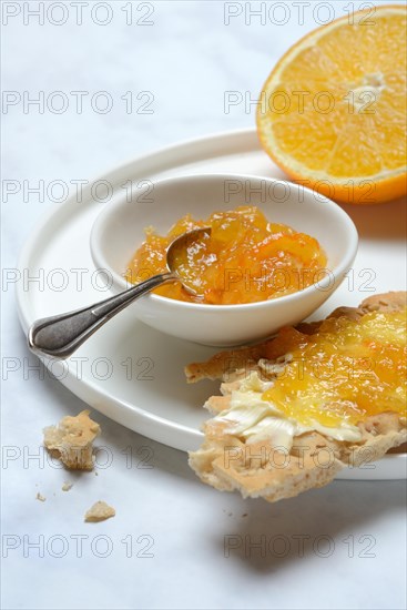 Orange marmalade in small bowls and on crispbread