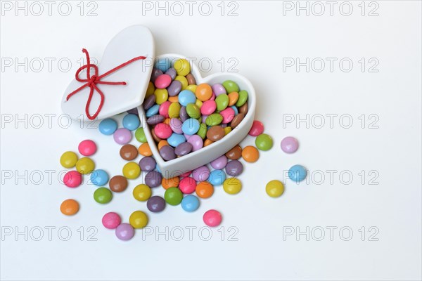 Chocolate lentils in heart-shaped container, Smartie