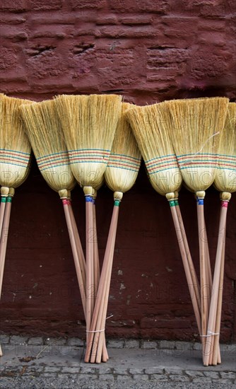 Set of yellow straw broom in a bazaar