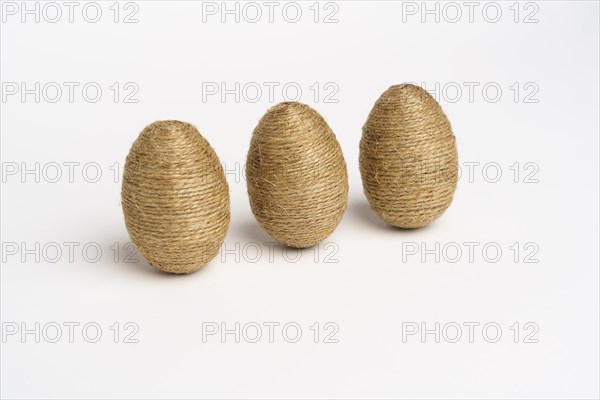 Hand wrapped easter eggs with jute twine, isolated white background. Studio