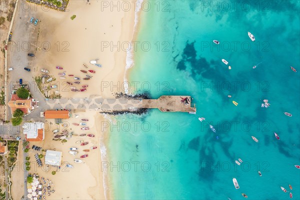 Pier and boats on turquoise water in city of Santa Maria, island of Sal, Cape Verde, Africa