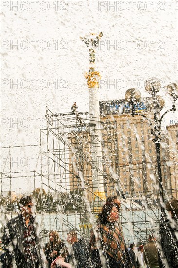 Statue of an angel made of copper and gold plated standing on a tall pillar in the center of Kiev