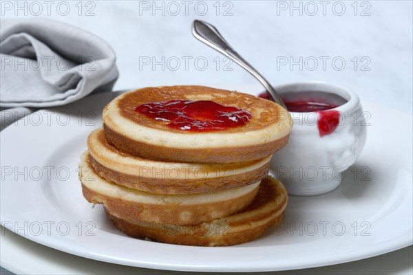 Pancake with raspberry jam and spoon