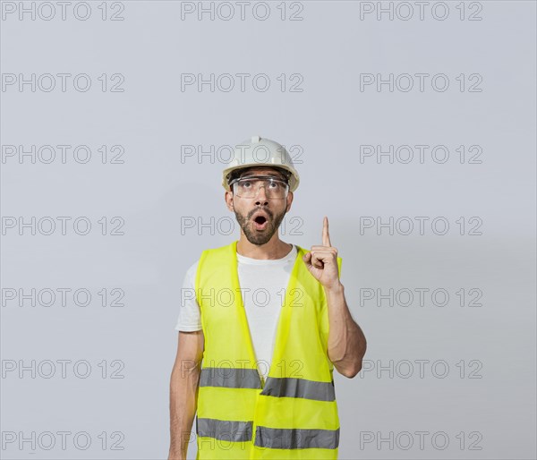 Amazed engineer man pointing up, Surprised young architect pointing up, Amazed engineer pointing at an advertisement. Concept of an engineer with astonished face pointing at blank space