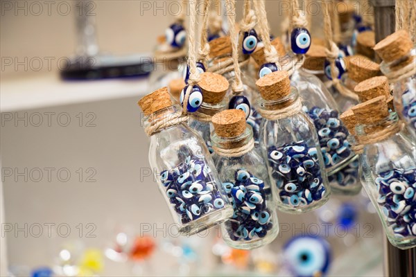 Little transparent glass bottle filled with blue evil eye beads