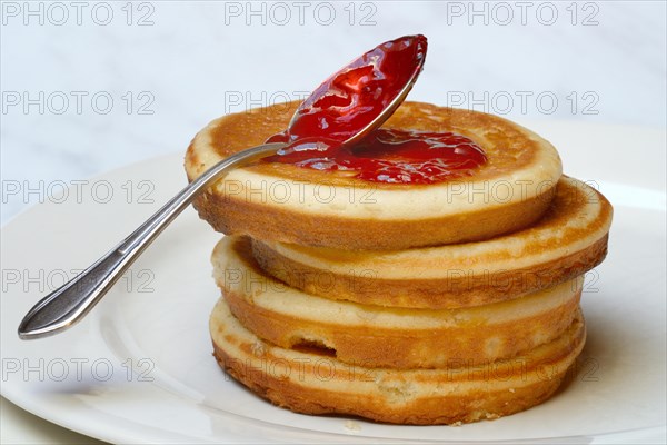 Pancake with raspberry jam and spoon