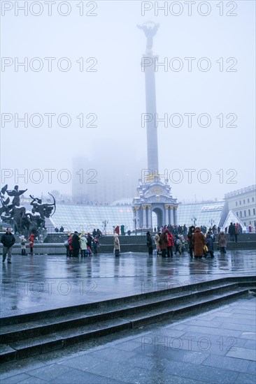 Statue of an angel made of copper and gold plated standing on a tall pillar in the center of Kiev