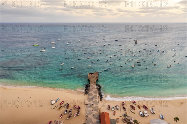 Pier and boats on turquoise water in city of Santa Maria, island of Sal, Cape Verde, Africa