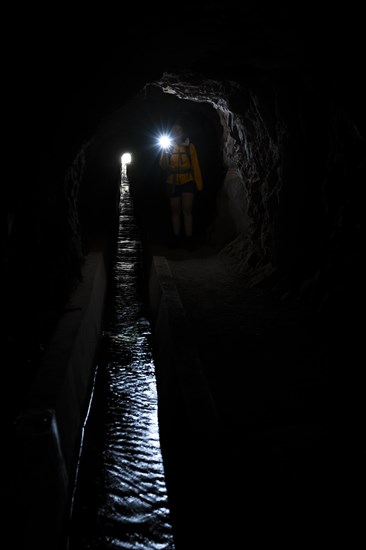 Hiker in a tunnel at Levada do Moinho, Ponta do Sol, Madeira, Portugal, Europe