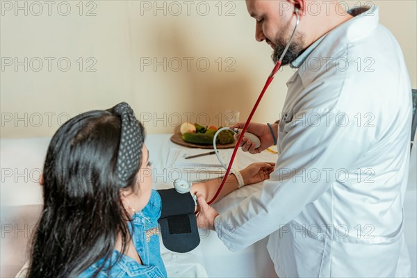 Nutritionist measuring blood pressure to patient. Measuring blood pressure to patient in the office, Nutritionist man measuring blood pressure to female patient in office