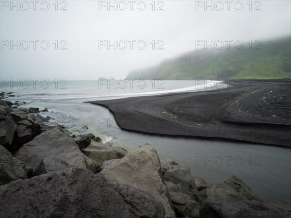 Rainy atmosphere, cliff in the fog, rock Reynisdrangar in the water, at Reynisfjara beach, black lava beach, Vik, South Iceland, Iceland, Europe