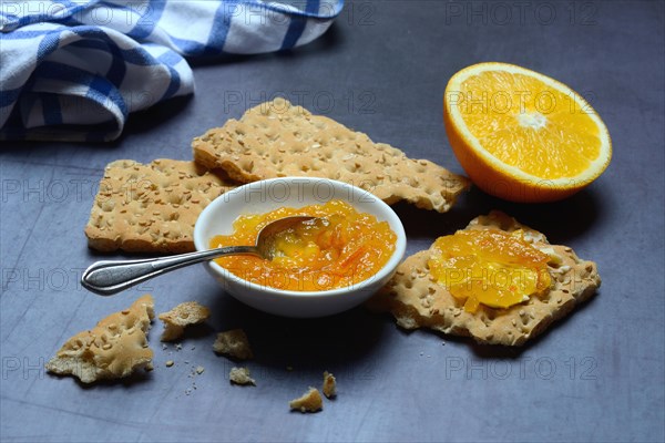 Orange marmalade in small bowls and on crispbread