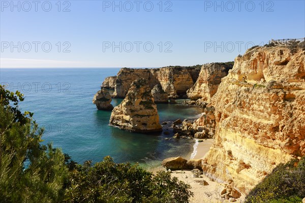 Beautiful cliffs and rock formations by the Atlantic Ocean at Marinha Beach in Algarve, Portugal, Europe