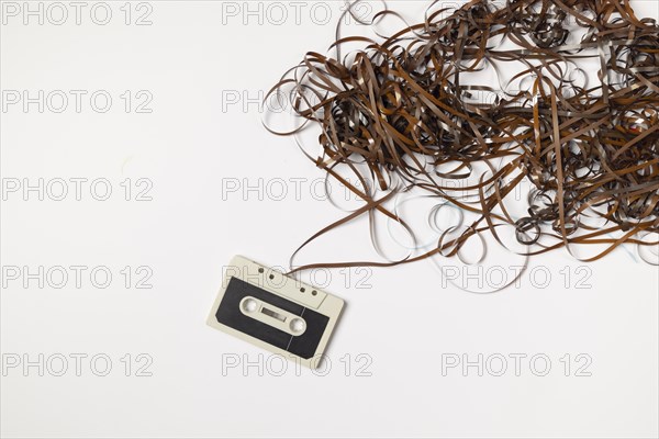 Old compact cassette with tape spaghetti, white background