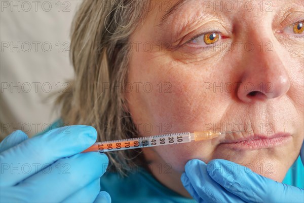 Older woman injected in lips Hyaluronic acid, Woman in beauty salon. plastic surgery clinic