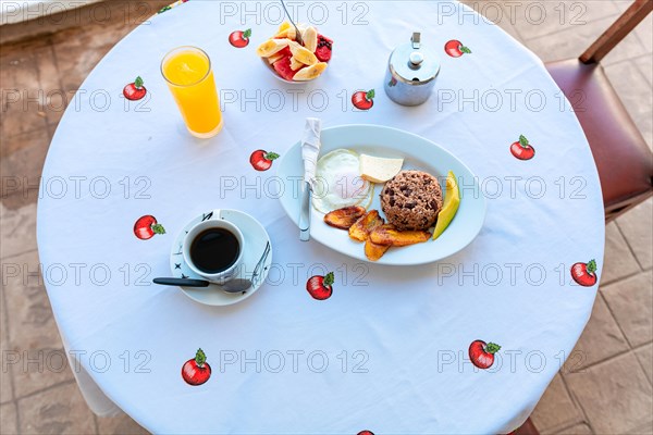 Top view of a breakfast served on the table. A traditional breakfast served on the table, gallopinto with coffee and fruit salad and orange juice