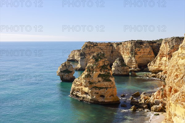 Beautiful cliffs and rock formations by the Atlantic Ocean at Marinha Beach in Algarve, Portugal, Europe