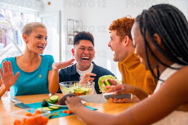 Portrait of a group of friends preparing vegetarian food. Preparing the salad and having fun around the house