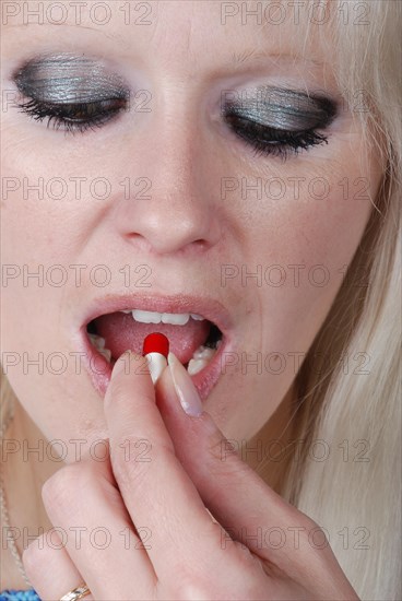 Woman holding a painkiller between finger