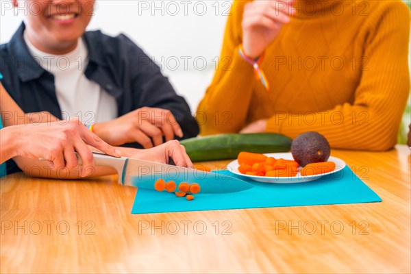 Group of friends preparing vegetarian food. They prepare food and have fun in the kitchen, lifestyle