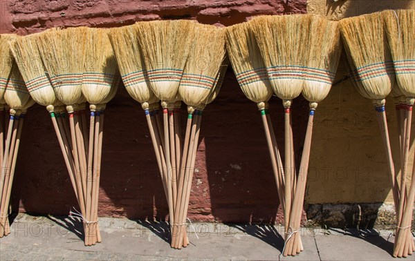 Set of yellow straw broom in a bazaar