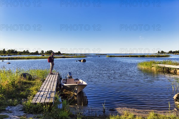 Hikers on a jetty in Svedjehamn, idyll on the Baltic coast, Bjoerkoeby, Korsholm, Mustasaari, Kvarken Archipelago Nature Reserve, UNESCO World Heritage Site, Ostrobothnia, Finland, Europe