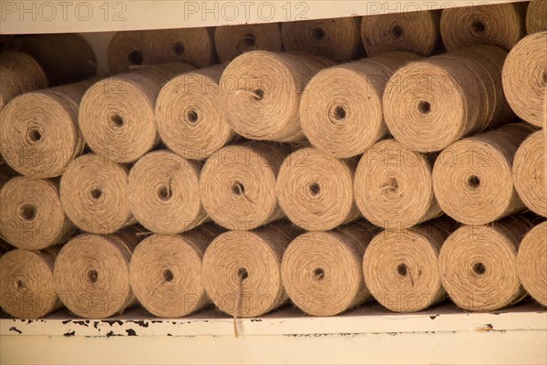 Plenty of spools or rolls of brown color linen string