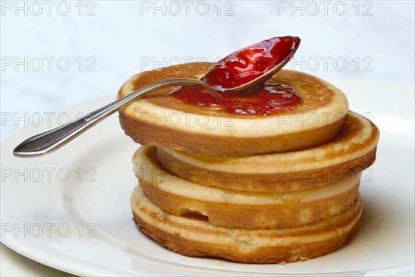 Pancake with raspberry jam and spoon