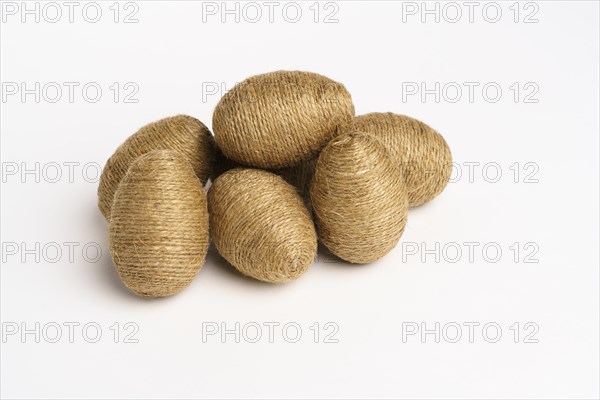 Hand wrapped easter eggs with jute twine, isolated white background. Studio